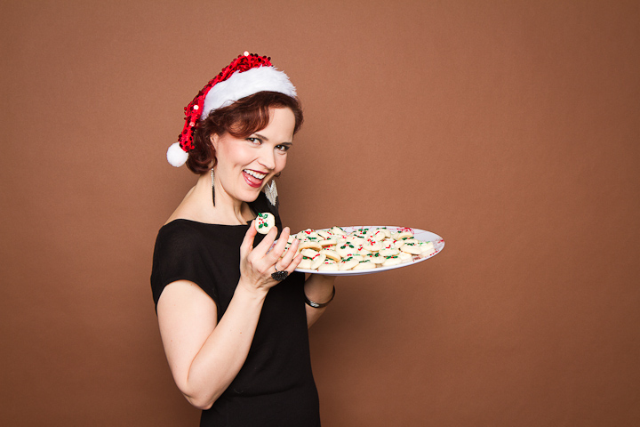 Woman in Santa hat passes out cookies at Christmas party
