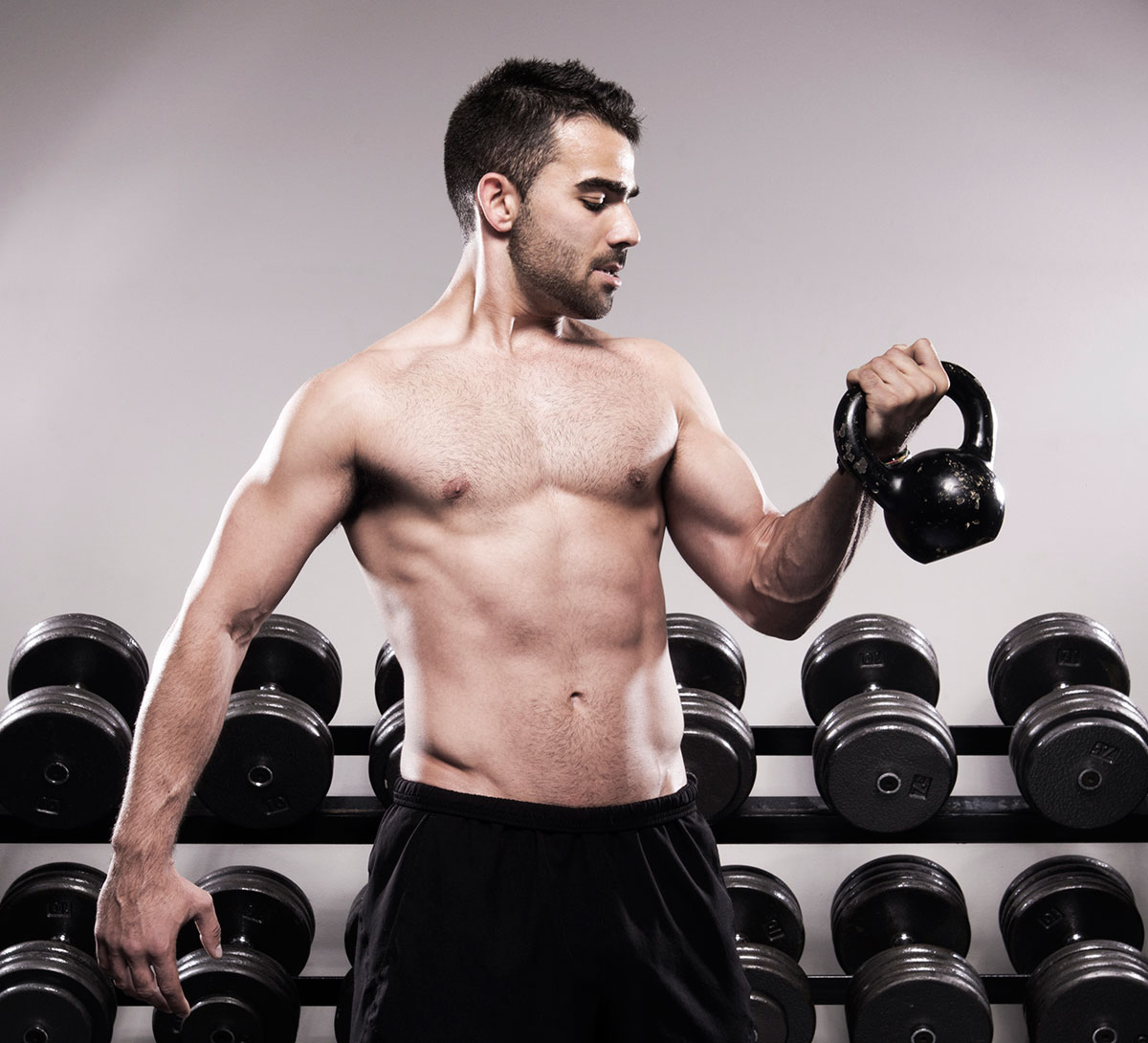 West Coast Fitness instructor demonstrates arm curls with a kettle bell | Commercial Photography